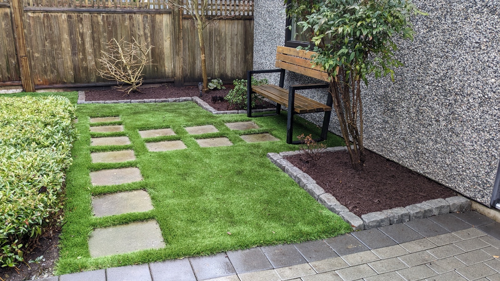 Peaceful back yard with stepping-stone lawn and bench